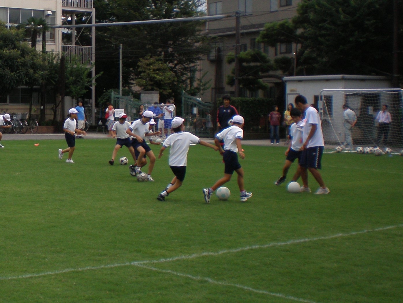 芝生化された校庭でサッカー教室が行われている様子