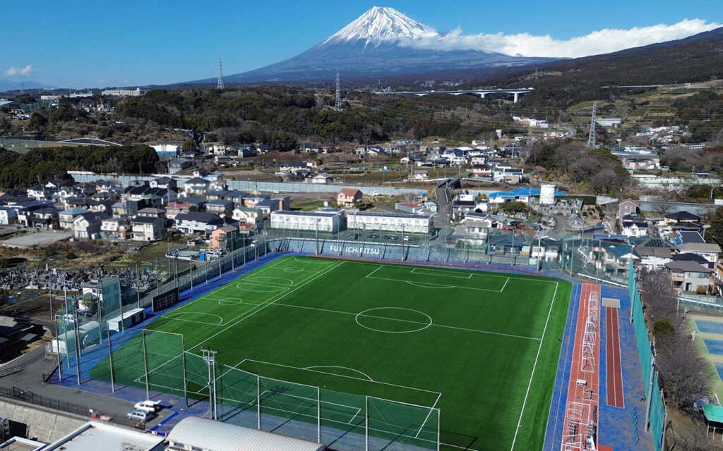富士山を背景にした富士市立高等学校屋外運動場の航空写真