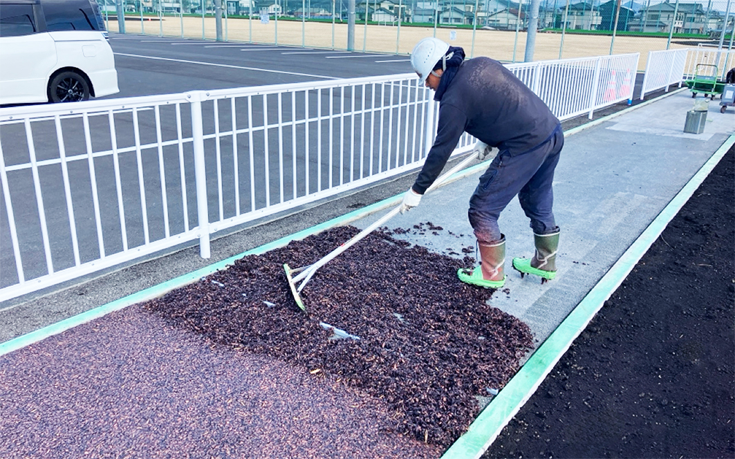 木質材をレーキを使って敷均す様子