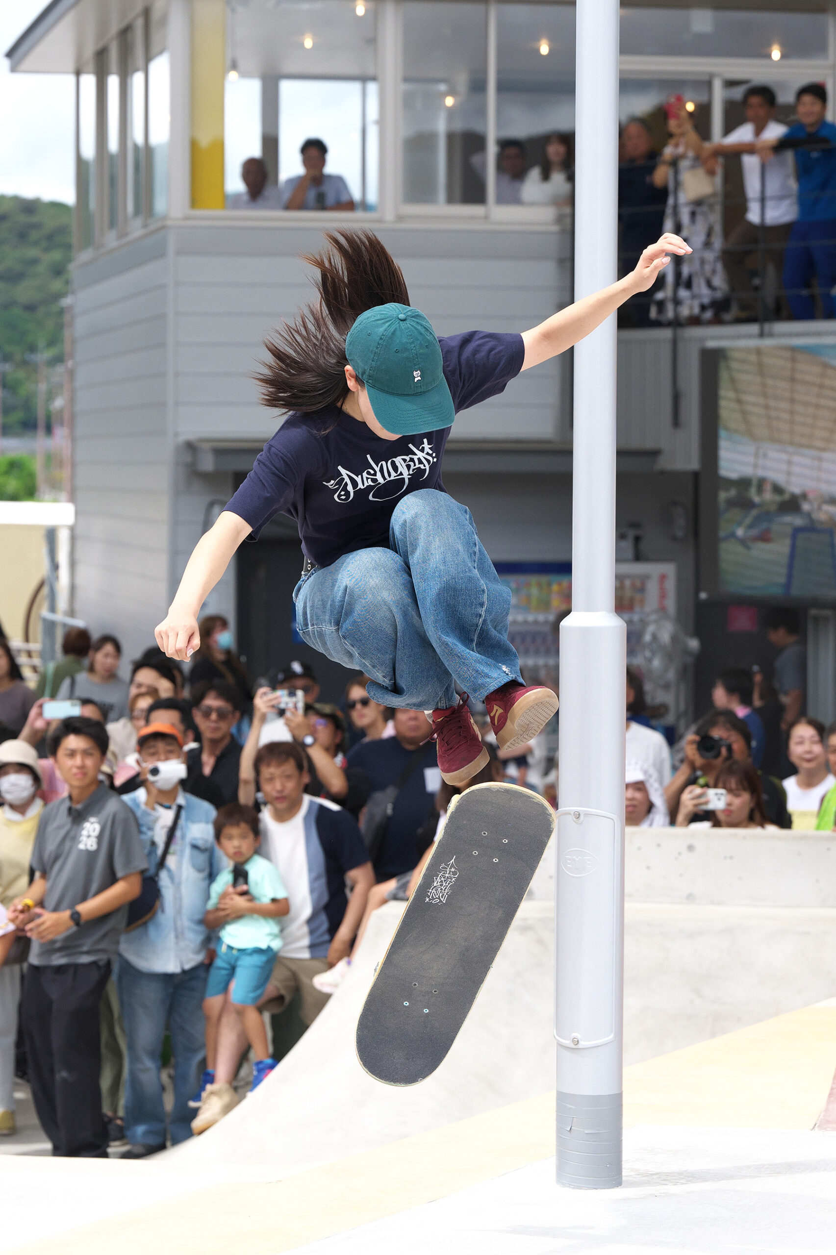 緑の帽子をかぶり、大きくジャンプする吉沢恋選手