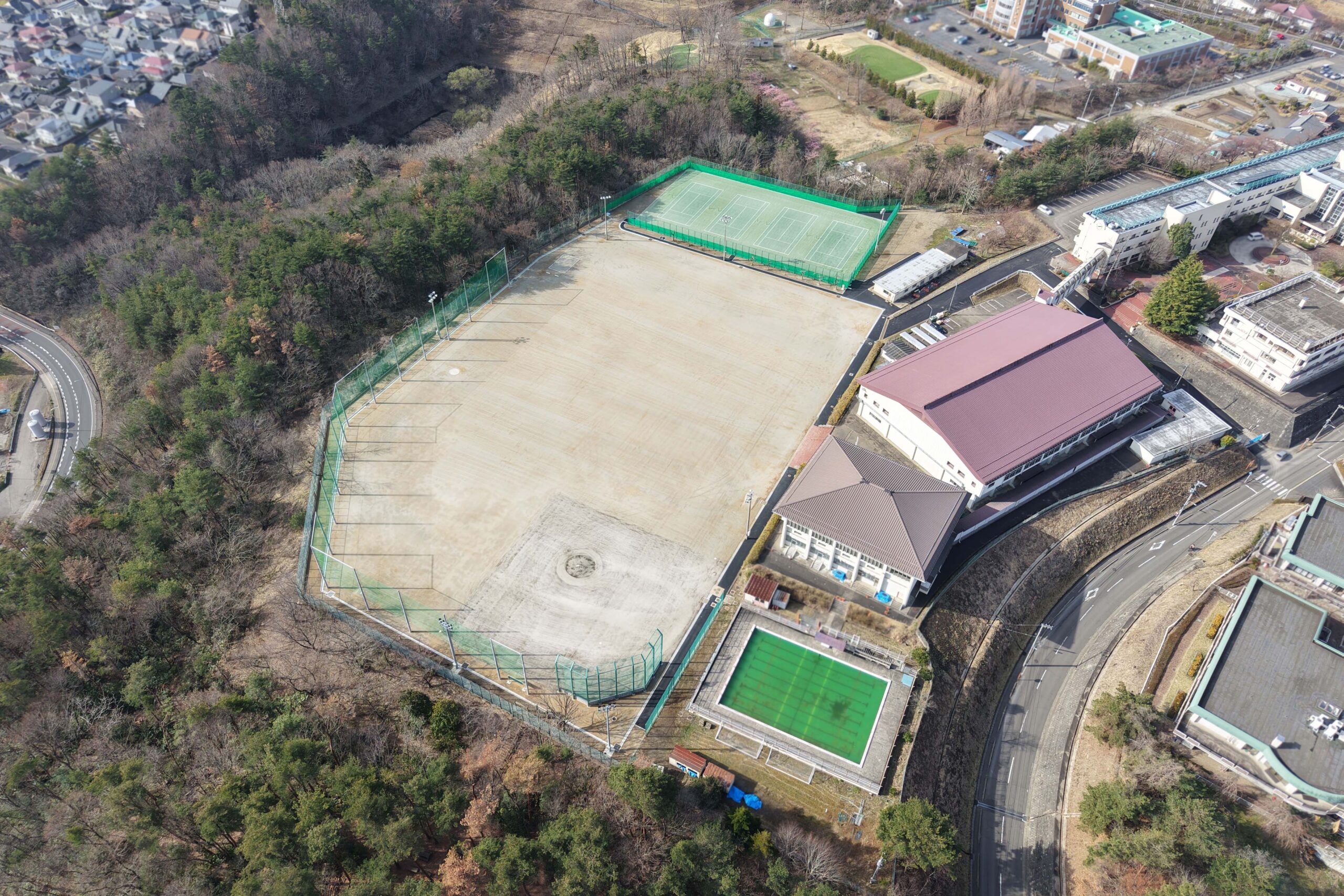学校校舎、プール、グラウンド、テニスコートをドロップで上空から撮影した