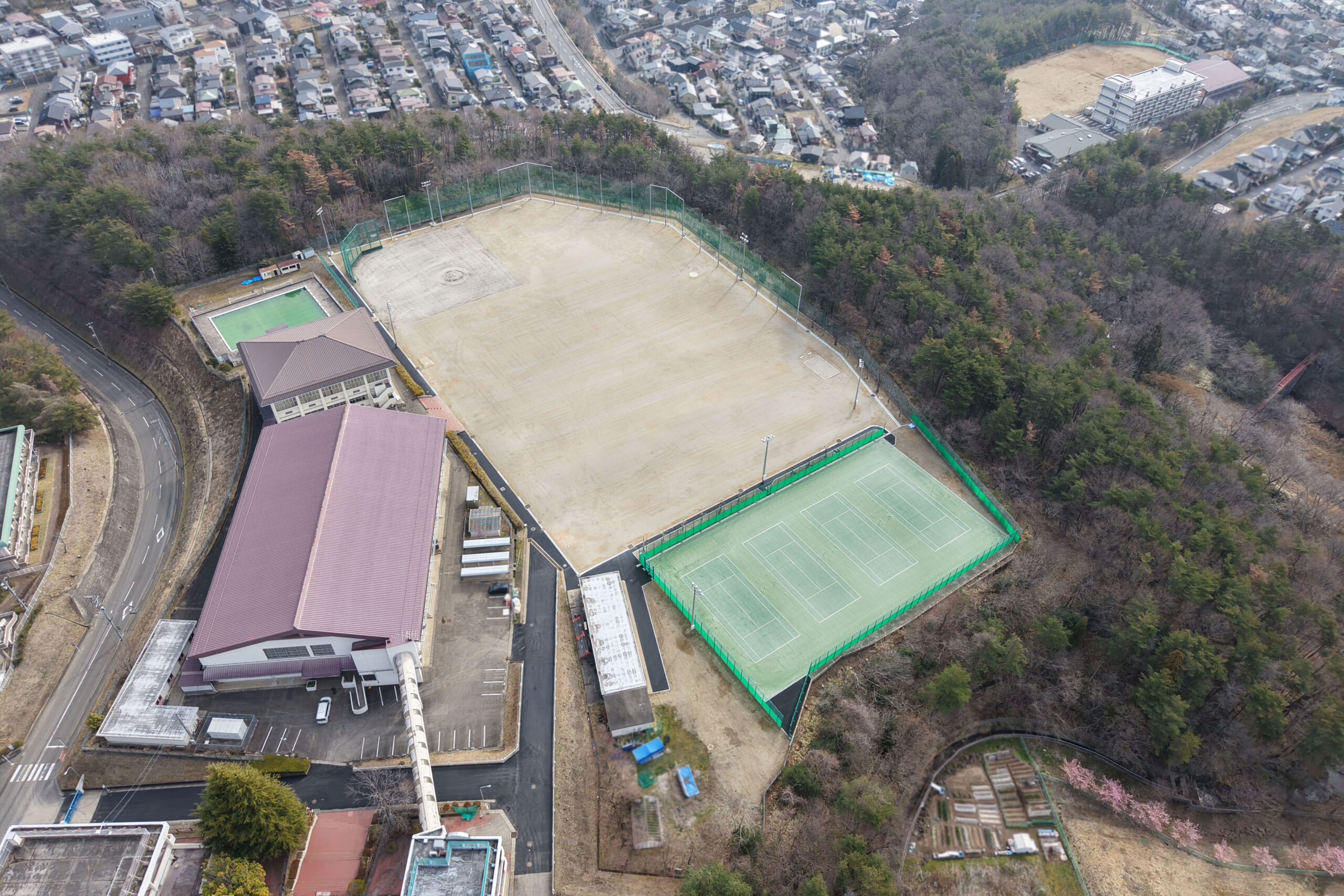 学校校舎、プール、グラウンド、テニスコートをドロップで上空から撮影した