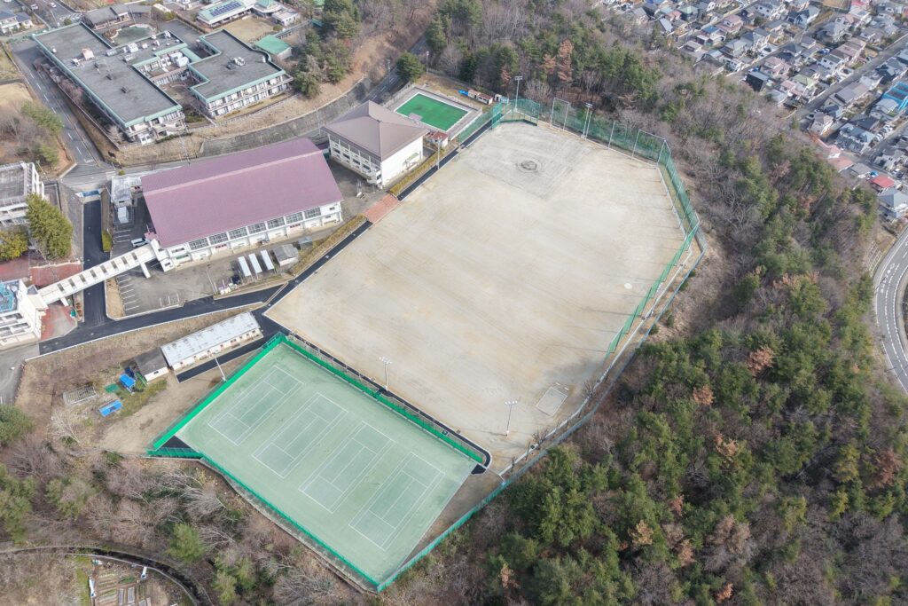 学校校舎、プール、グラウンド、テニスコートをドロップで上空から撮影した